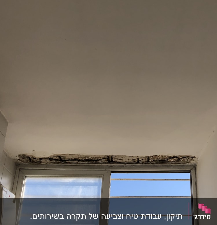 תקרה עם קילופי צבע מעל חלון